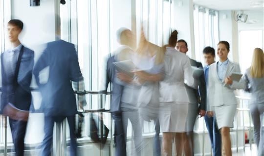 Group of well dressed business men and women walking together